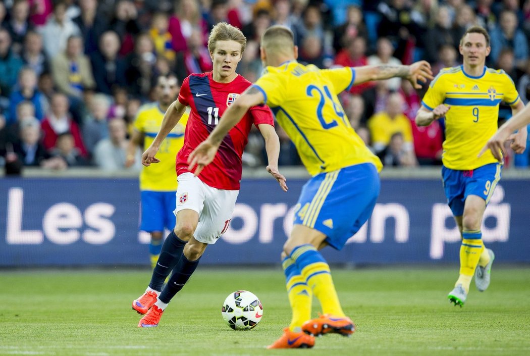 Martin Ödegaard se snaží obejít švédského protihráče v přátelském zápase v Norsku