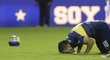 Útočník Carlos Tévez líbá trávník na stadionu Bombonera po návratu do klubu Boca Juniors