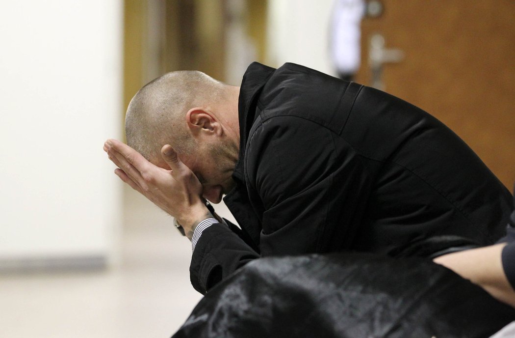 Tomáš Řepka si drží hlavu v dlaních během čekání před soudní síní, ve které se koná jeho rozvodové stání