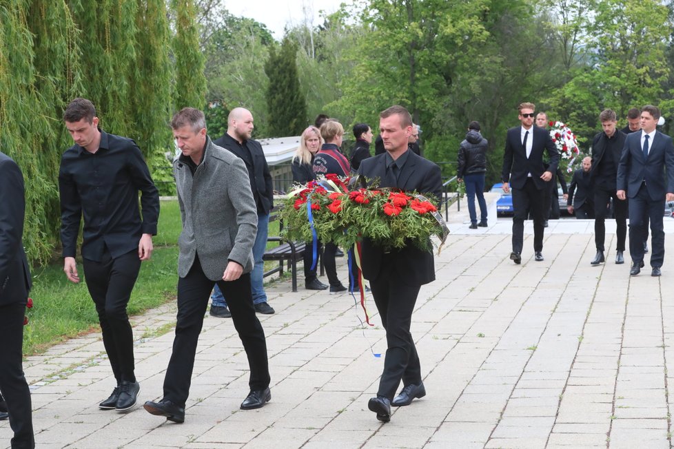 Smuteční hosté nesou květiny na místo Josefova posledního odpočinku