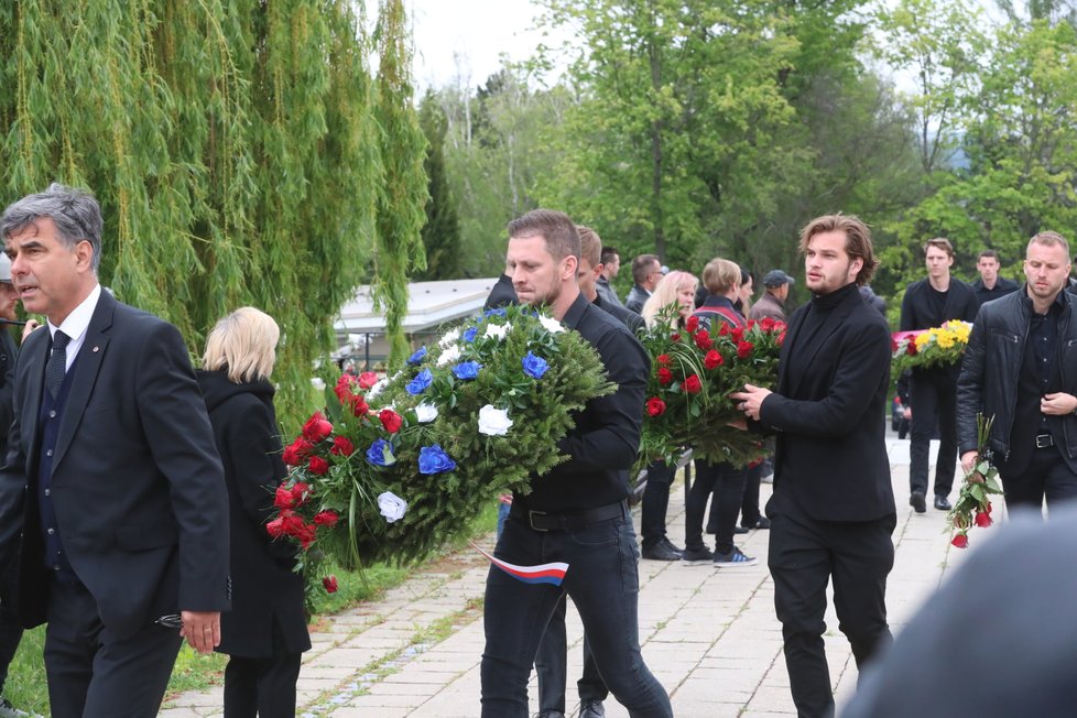 Smuteční hosté nesou květiny na místo posledního odpočinku Josefa Šurala