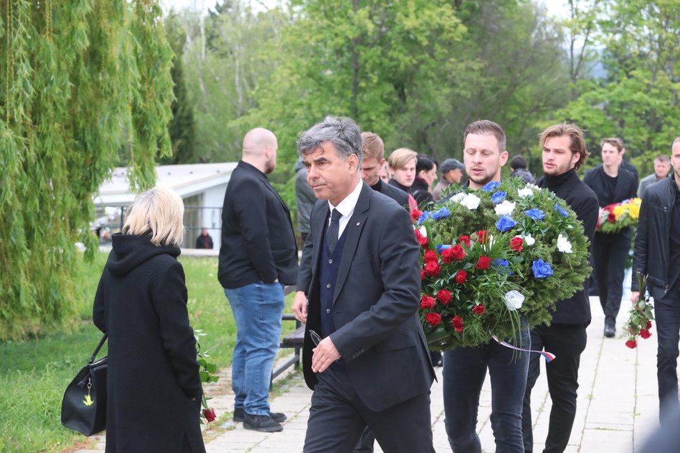 Smuteční hosté nesou květiny na místo posledního odpočinku Josefa Šurala