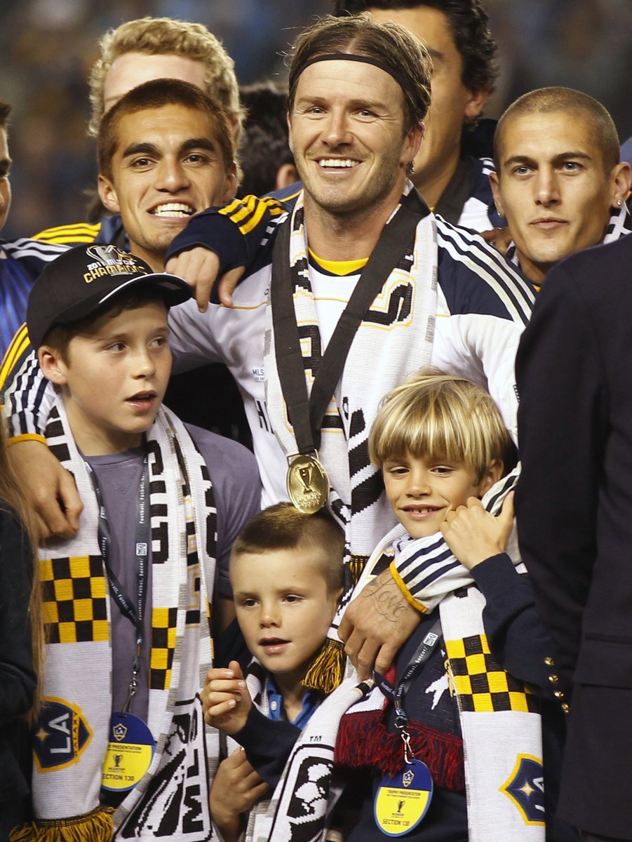 David Beckham objímá po vítězství ve finále MLS své syny (zleva) Brooklyna, Cruze a Romea.