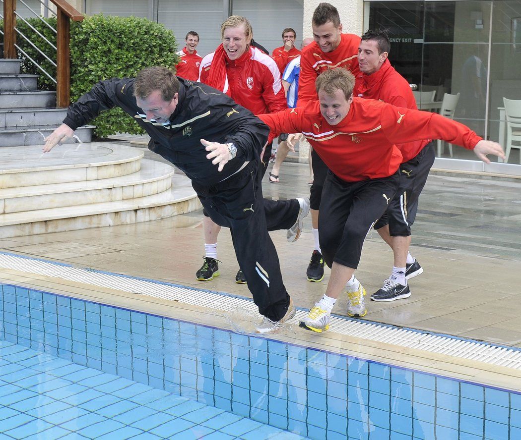 Pavel Vrba a David Limberský skáčou do bazénu během plzeňského soustředění