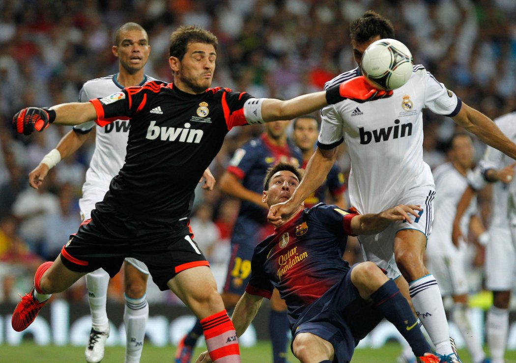 Gólman Realu Madrid Iker Casillas zasahuje před Messim