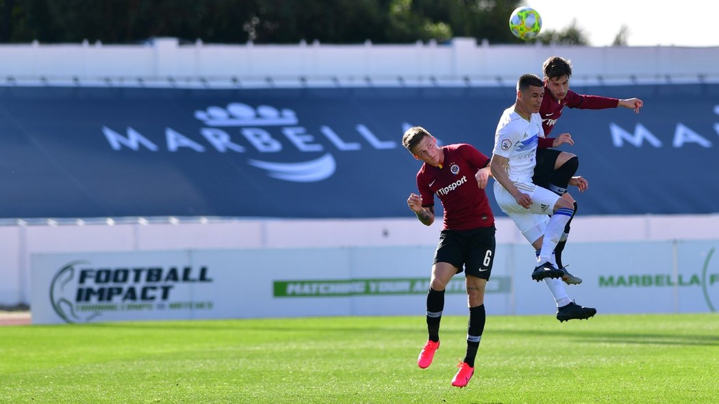 Fotbalisté Sparty Martin Graiciar (6) a Michal Sáček (vpravo) v hlavičkovém souboji se soupeřem z Marbelly