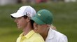 Soustředíš se, Rory? Dánská tenistka Caroline Wozniacká objímá svého přítele Roryho McIlroye při exhibiční jamce po konci tréninku před golfoým Masters v Augustě