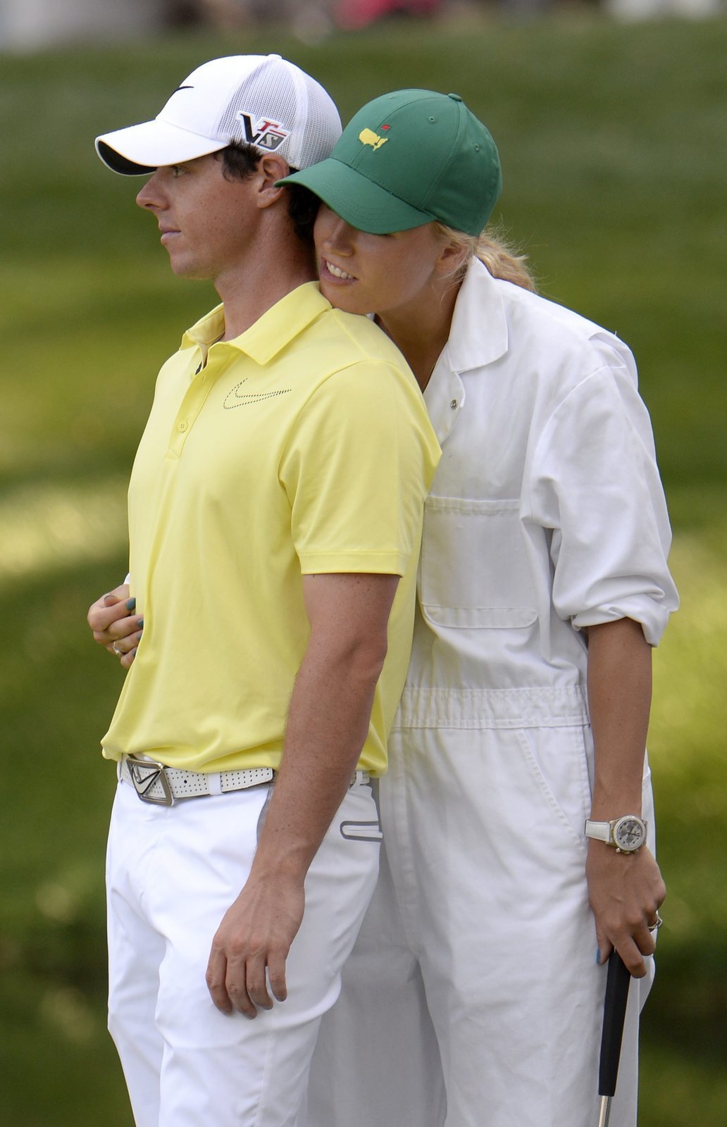 Soustředíš se, Rory? Dánská tenistka Caroline Wozniacká objímá svého přítele Roryho McIlroye při exhibiční jamce po konci tréninku před golfoým Masters v Augustě