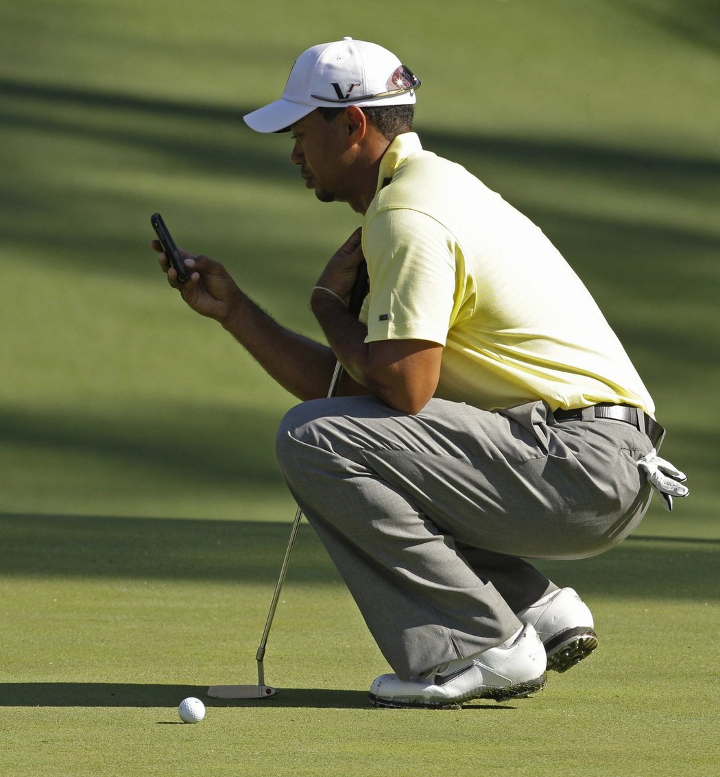Tiger Woods kontroluje během tréninkového kola turnaje Masters v Augustě svůj mobilní telefon