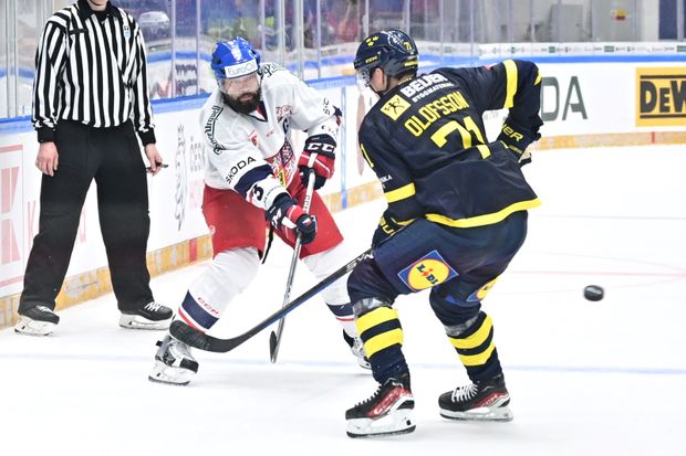 Řízný český bek Radko Gudas nahazuje puk na branku přes Švéda Olofssona Řízný český bek Radko Gudas nahazuje puk na branku přes Švéda Olofssona