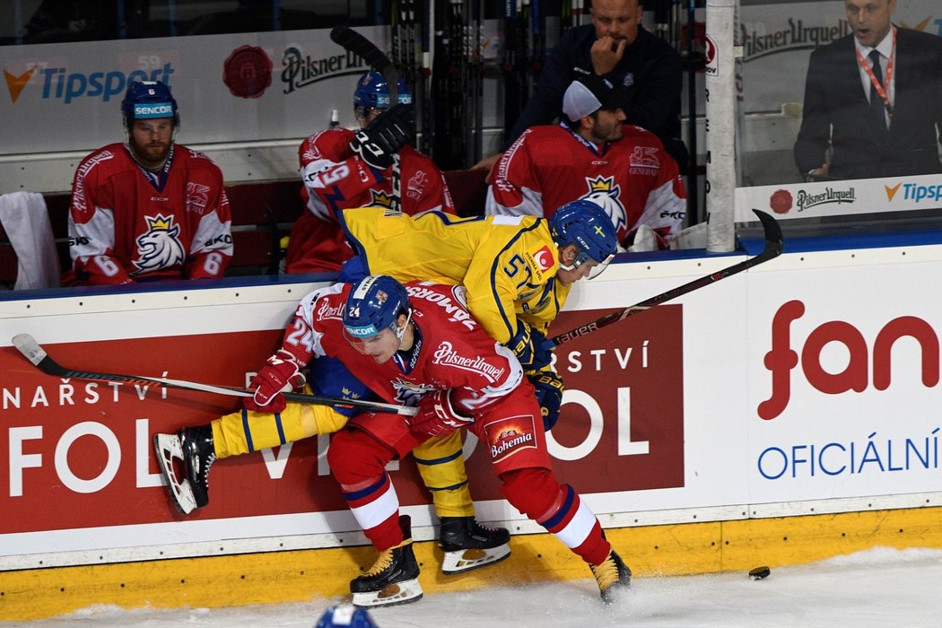 Český obránce Petr Zámorský (v popředí) a útočník Anton Wedin (v pozadí) v souboji u mantinelu během utkání turnaje Karjala Cup mezi Českem a Švédskem