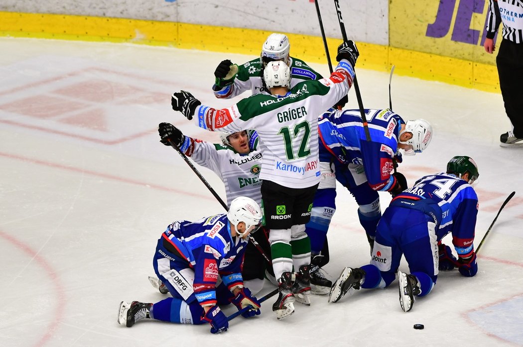 Karlovarští hokejisté se radují z gólu nad smutnícími hráči Komety