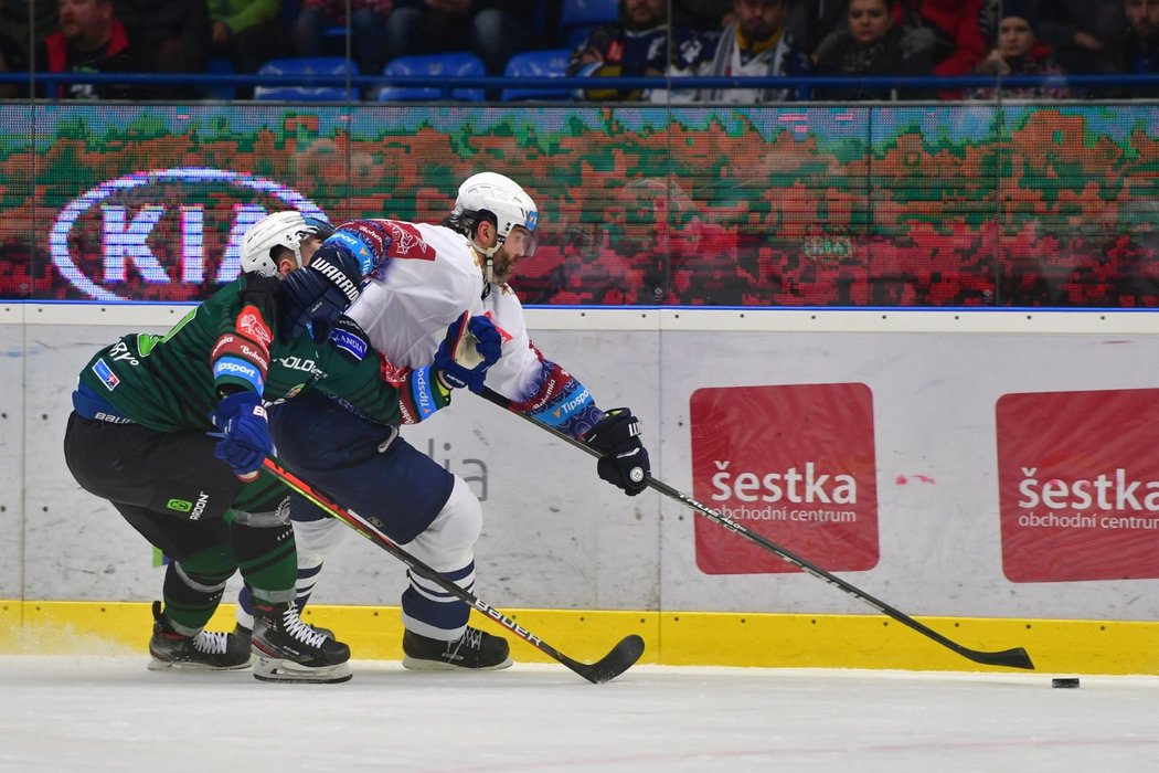 Jaromír Jágr se svojí dlouhou hokejkou drží dál kotouč od karlovarského soupeře