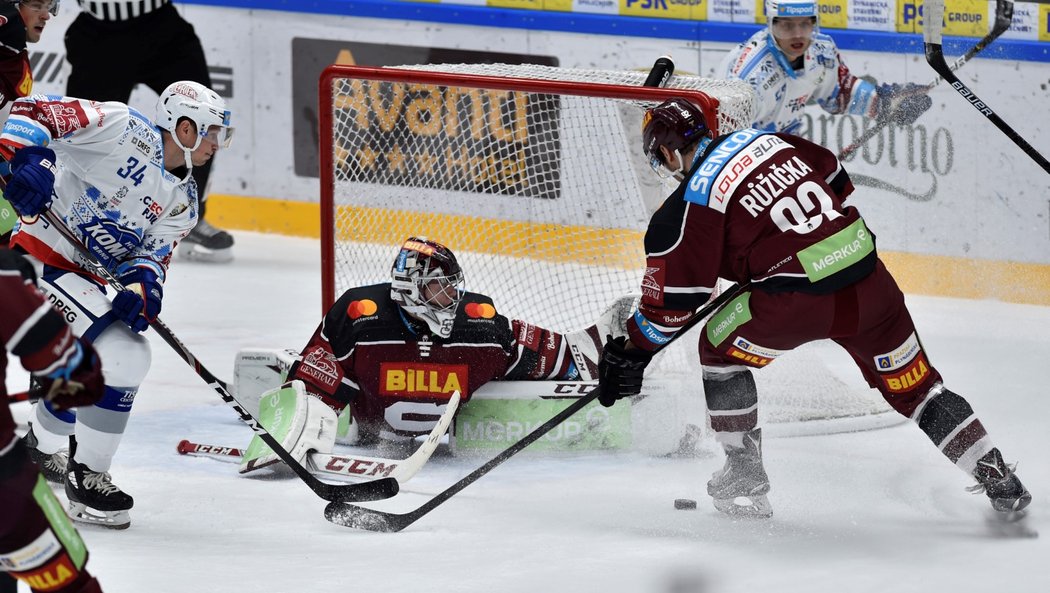 Gólman Sparty Jakub Sedláček si musí dávat pozor na situaci, kterou před jeho brankou rozvířil Daniel Rákos, debutant v brněnském dresu (vlevo)