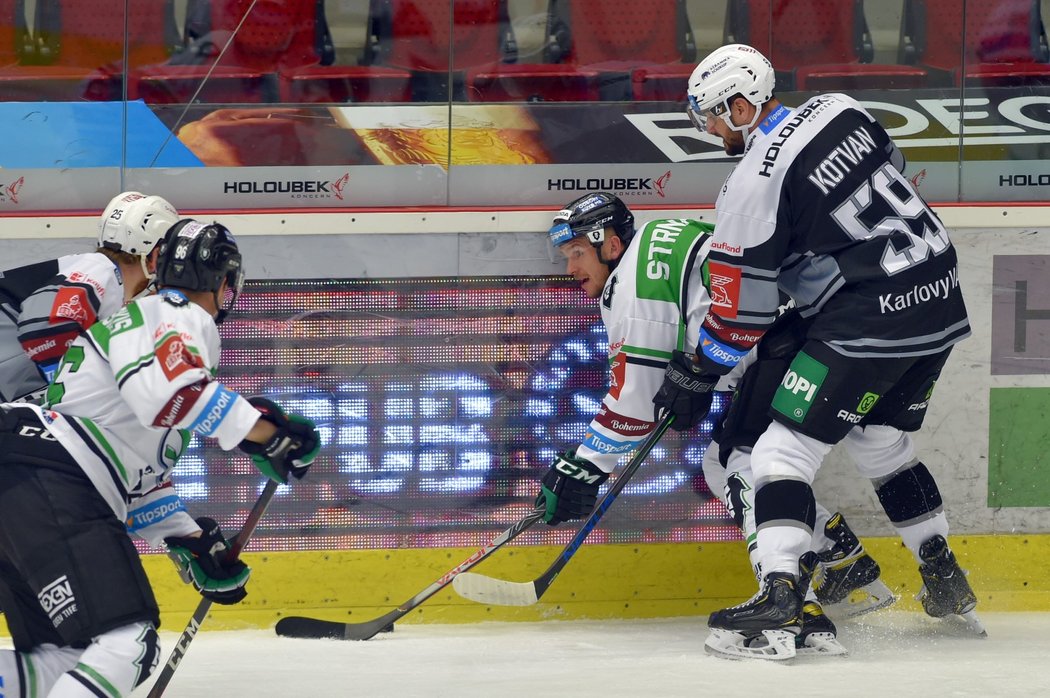 Útočník Mladé Boleslavi Jakub Strnad soupeří u mantinelu o puk s karlovarským bekem Oldrichem Kotvanem