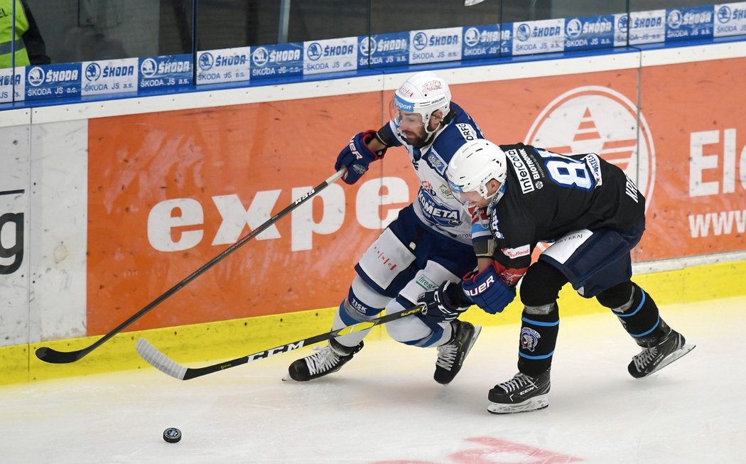 Bek Komety Peter Trška v souboji o puk s plzeňským útočníkem Jaroslavem Kracíkem