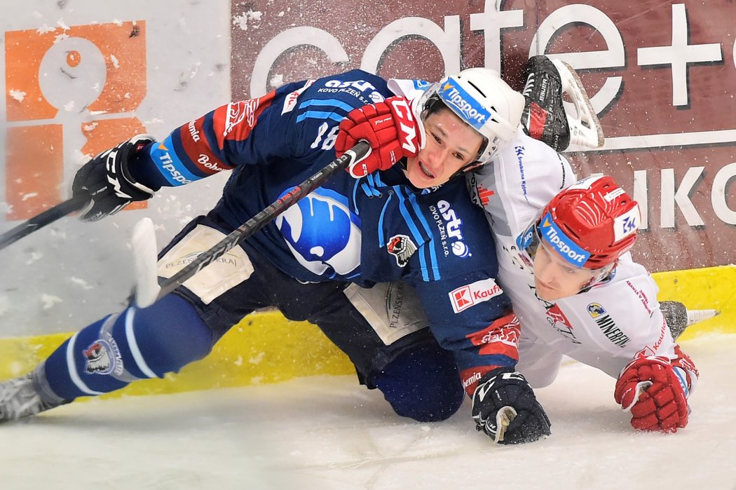 Ocelář Michal Kovařčík stahuje sebou k ledu plzeňského útočníka Petra Kodýtka