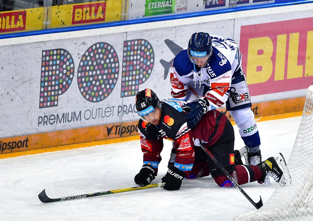 Sparťan Tomáš Šmerha se snaží zvednout z ledu při souboji s bekem Janem Štencelem z Vítkovic