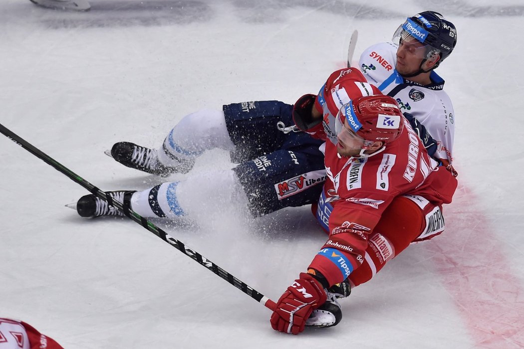 Liberecký střelec Michal Bulíř padá k ledu během souboje s Danielem Kurovským z Třince