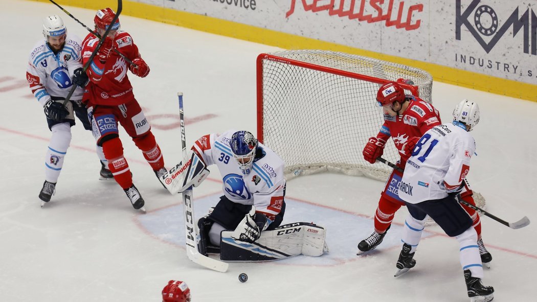 Mladý plzeňský brankář Dominik Pavlát se chytá lapit kotouč, zatímco parťáci z obrany drží dál Oceláře