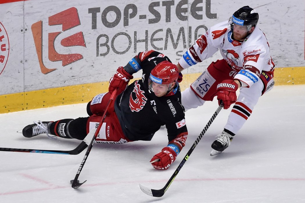 Třinecký Ocelář Marko Daňo padá k ledu v souboji s obráncem Tomášem Černým z Olomouce