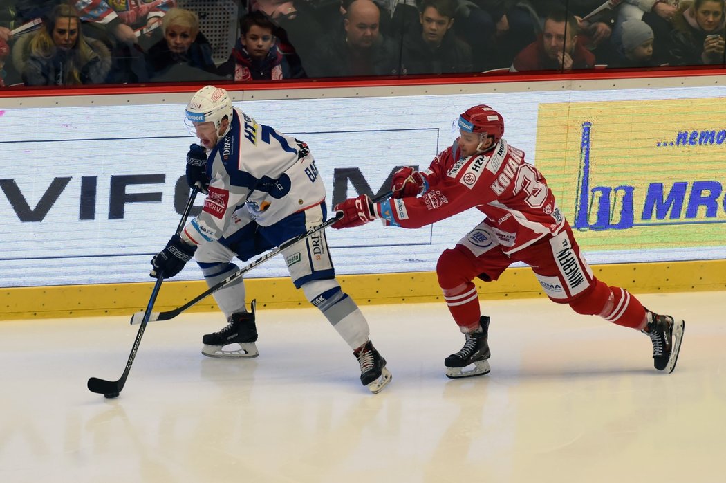 Třinecký útočník Ondřej Kovařčík sápe po puku, který drží obránce Tomáš Bartejs z Brna