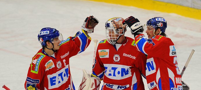 Pardubická radost: Petr Koukal (vlevo) a Aaron MacKenzie gratulují Dominiku Haškovi k vychytané nule