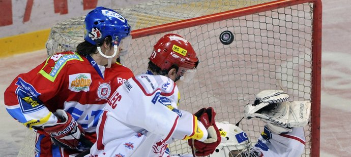 Zleva Jan Kolář z Pardubic bojuje před brankou Třince s Tomášem Malcem, v brance Peter Hamerlík