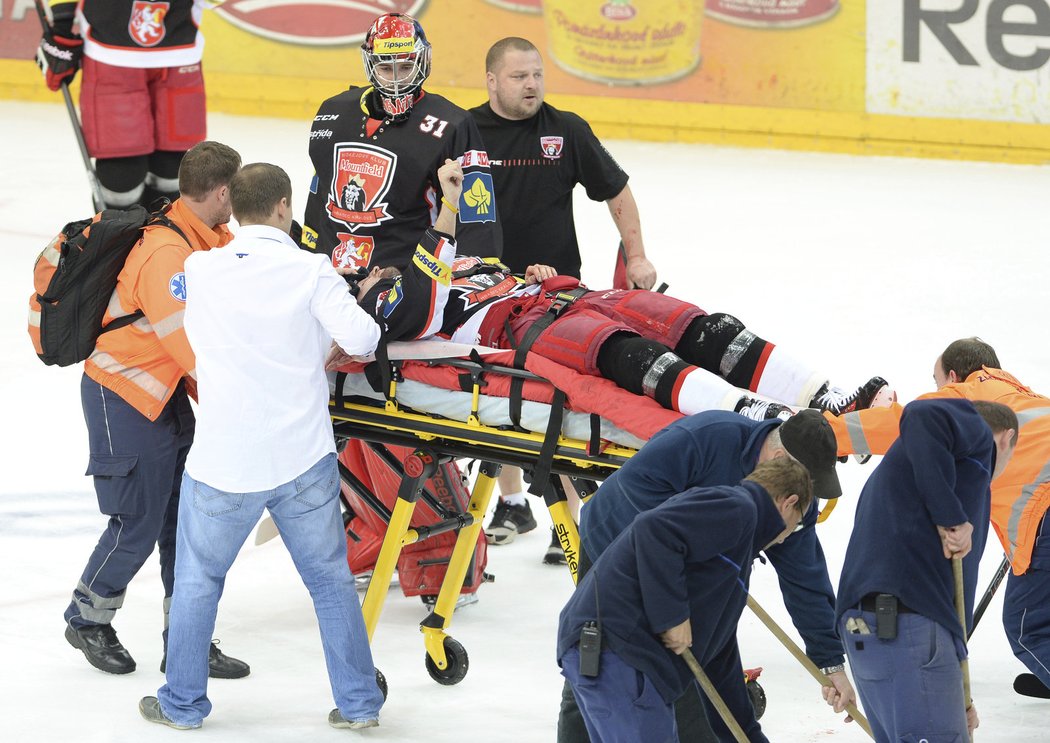 Zdravotníci odváží zraněního Petera Mikuše, který ukazuje fanouškům, že s ním snad nebude nic vážného