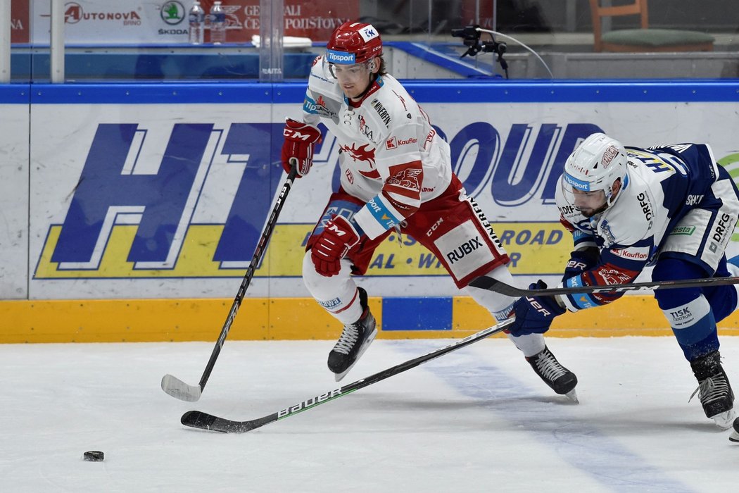 Třinecký Ocelář Michal Kovařčík v souboji o puk s Jakubem Valským z Komety Brno