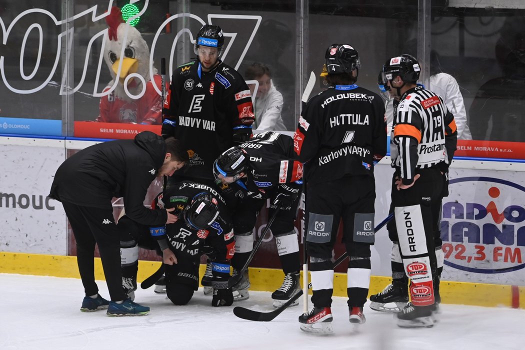 Karlovarští hokejisté pomáhají z ledu Tomáši Rachůnkovi, který nepříjemně narazil do mantinelu