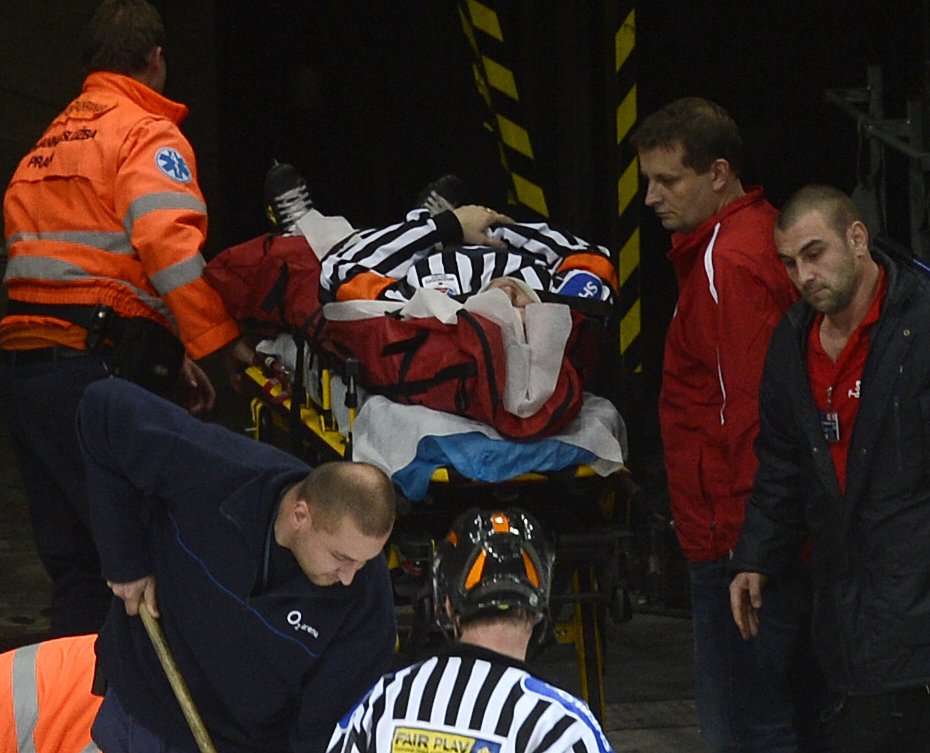 Zraněný hlavní rozhodčí Tomáš Horák opouští po zásahu pukem ledovou plochu na nosítkách