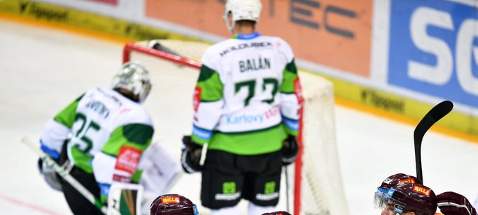 Sparťanští hokejisté se radují ze snižující trefy Andreje Kudrny na 1:2, karlovarský brankář Filip Novotný loví puk ze sítě