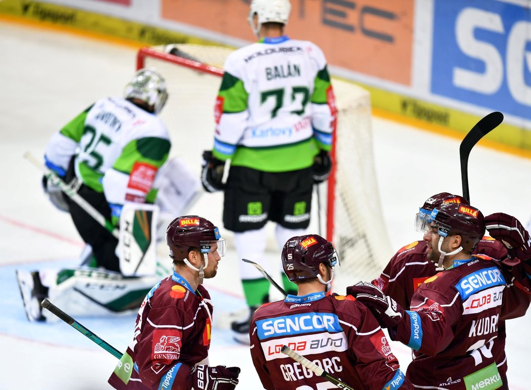 Sparťanští hokejisté se radují ze snižující trefy Andreje Kudrny na 1:2, karlovarský brankář Filip Novotný loví puk ze sítě