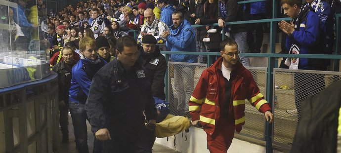 Lékaři odnášejí na nosítkách fanouška Vítkovic, který zkolaboval v závěru zápasu