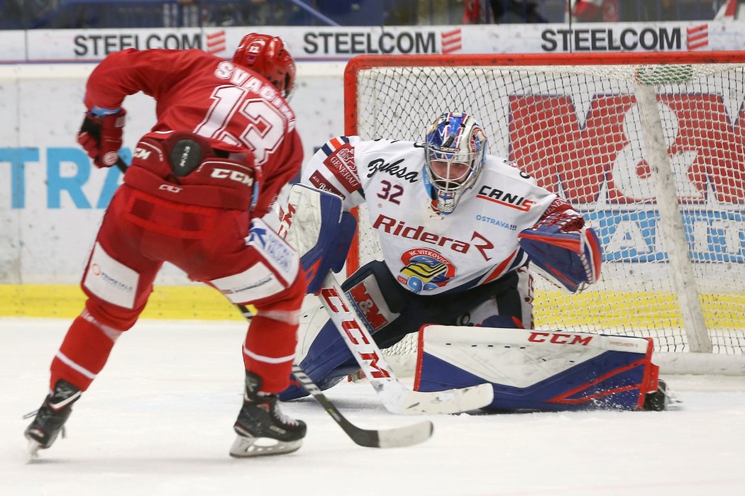 Vladimír Svačina z Třince se v úniku snaží překonat brankář Vítkovic Patrika Bartošáka v extraligovém derby