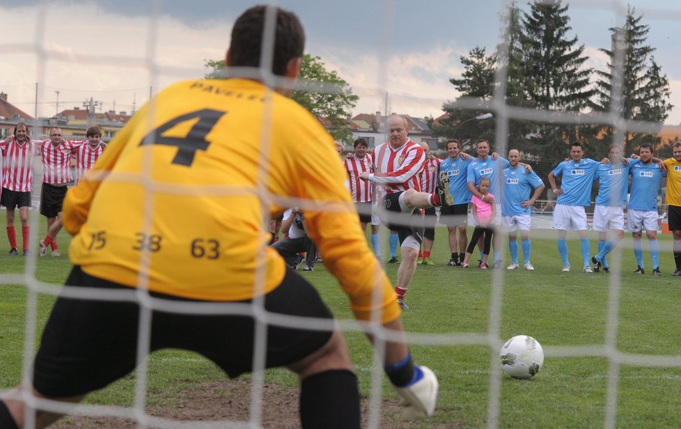 Herec David Novotný ze Slavoje Houslice střílí penaltu na Ondřeje Pavelce v bráně Rachna týmu