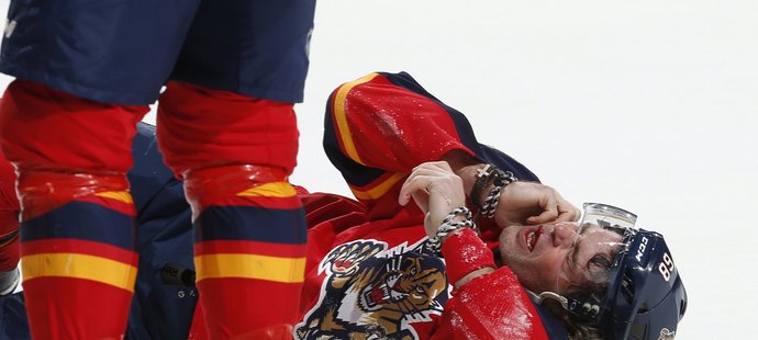 Jaromír Jágr leží na ledě po zásahu holí od útočníka Ottawy Alexe Chiassona