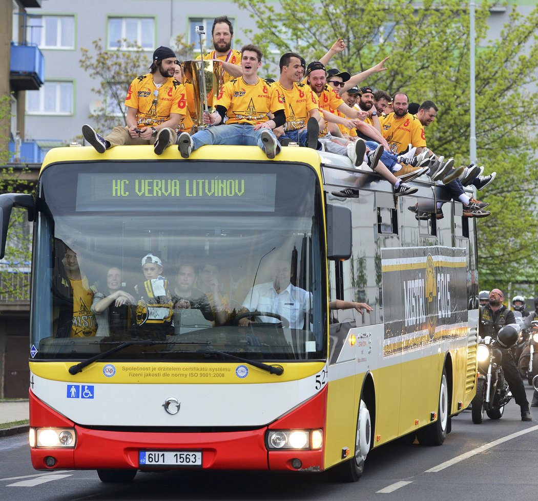 Hokejoví šampioni z Litvínova slaví na střeše autobusu městské hromadné dopravy.