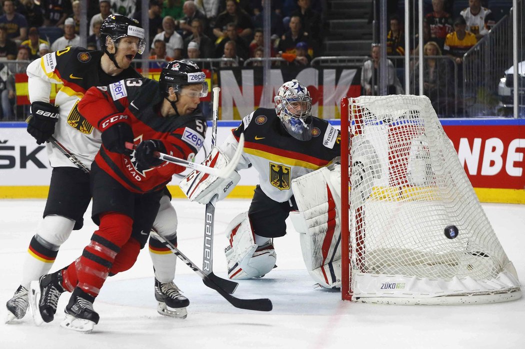 Philipp Grubauer sleduje, jak se Jeff Skinner hrne za kotoučem