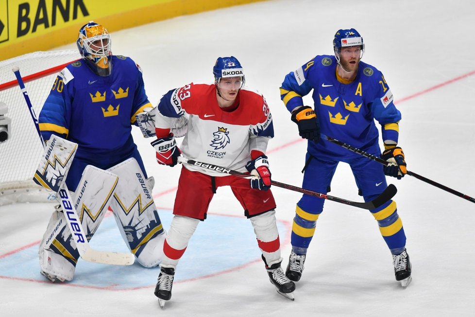 Dmitrij Jaškin (uprostřed) se snaží tečovat před Henrikem Lundqvistem (vlevo) za dohledu Erika Gustafssona (vpravo)