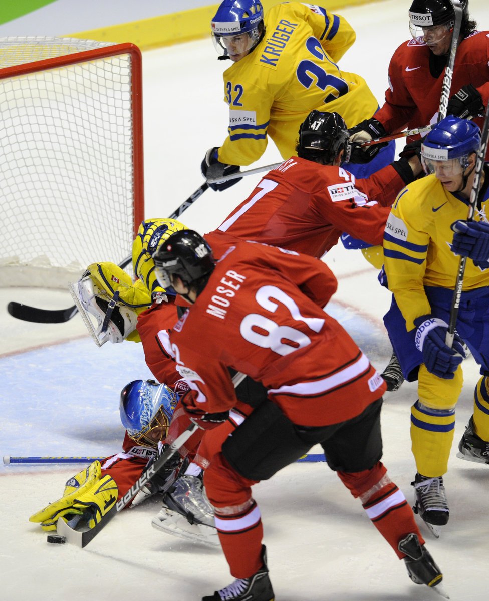 Švédští hokejisté se snaží překonat švýcarského brankáře: Zleva Leonardo Genoni (SUI), Simon Moser (SUI), Marcus Krüger (SWE), Carl Gunnarsson (SWE), Felicien Du Bois (SUI).