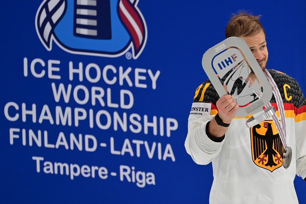 Moritz Muller s trofejí za druhé místo na mistrovství světa v hokeji