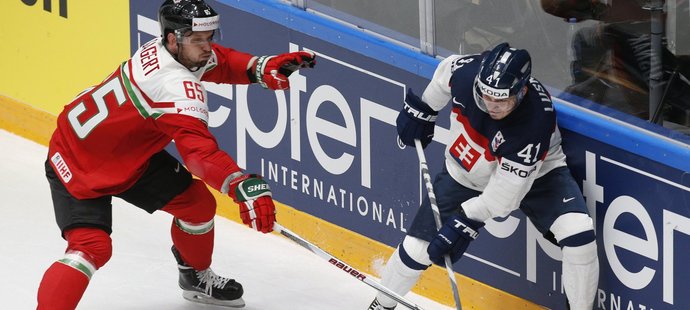 Slovenský hokejista Patrik Lušňák odehrává puk před maďarským soupeřem v utkání mistrovství světa.