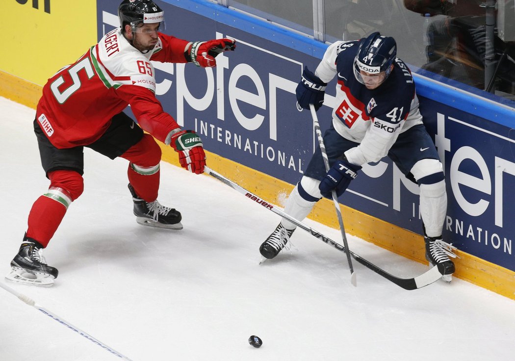 Slovenský hokejista Patrik Lušňák odehrává puk před maďarským soupeřem v utkání mistrovství světa