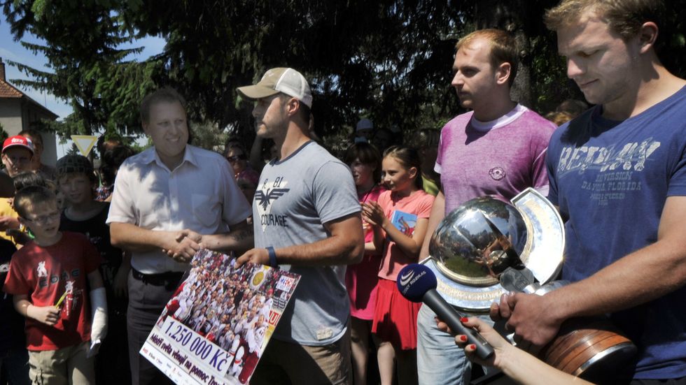 Hokejoví mistři světa (zprava) Petr Vampola, Miroslav Blaťák a Tomáš Rolinek předali 10. června starostovi obce Troubky Radku Brázdovi (vlevo) šek na 1.250.000 korun.