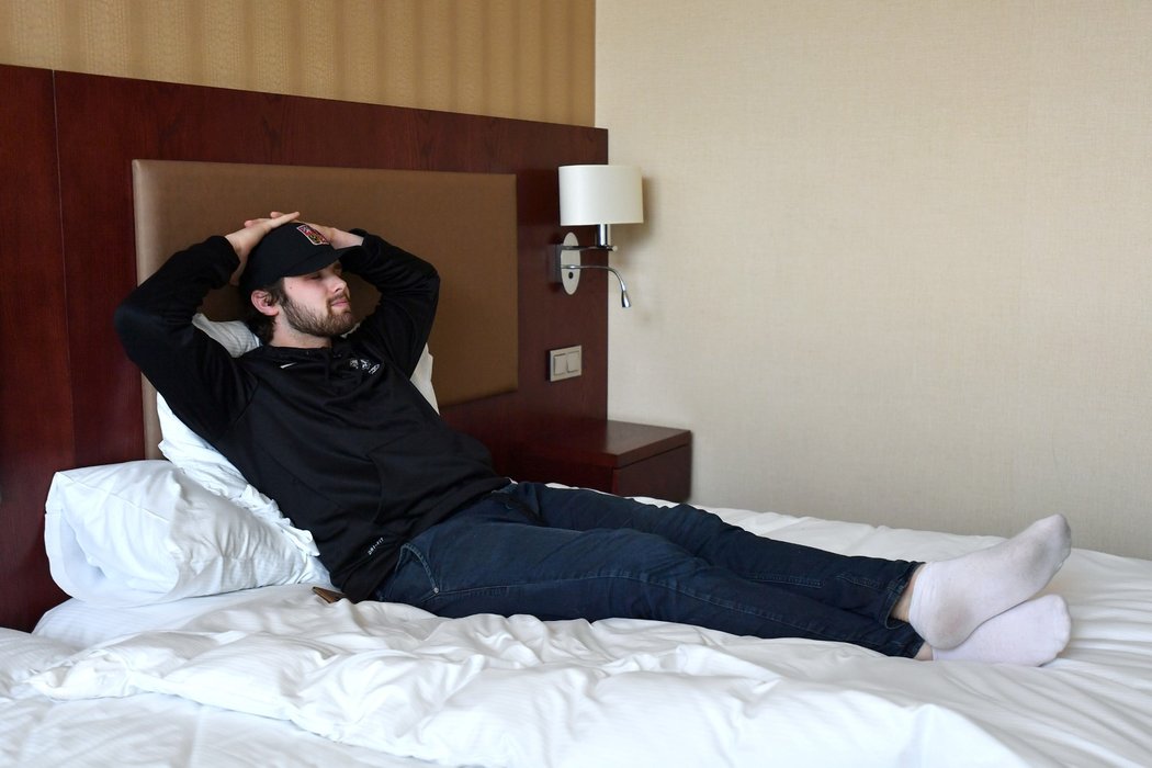 Patrik Bartošák pózuje na posteli během prohlídky hotelového pokoje v Bratislavě
