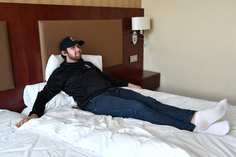 Patrik Bartošák pózuje na posteli během prohlídky hotelového pokoje v Bratislavě