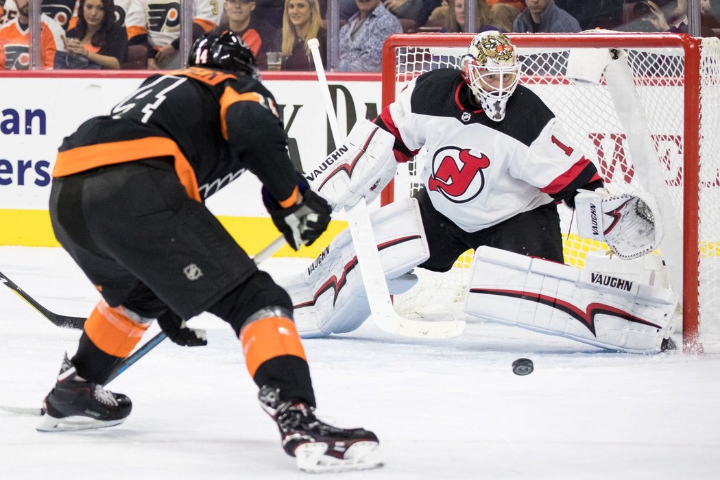 Brankář New Jersey Keith Kinkaid čelí nájezdu Travise Konecnyho z Philadelphie