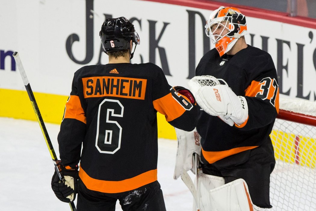 Hráč Philadelphie Travis Sanheim a gólman Brian Elliot se radují z vítězství